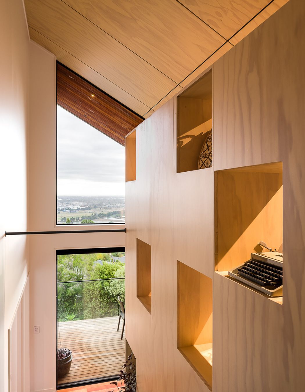 Open apertures in the large bookcase element serve to admit diffused light onto the stairs.