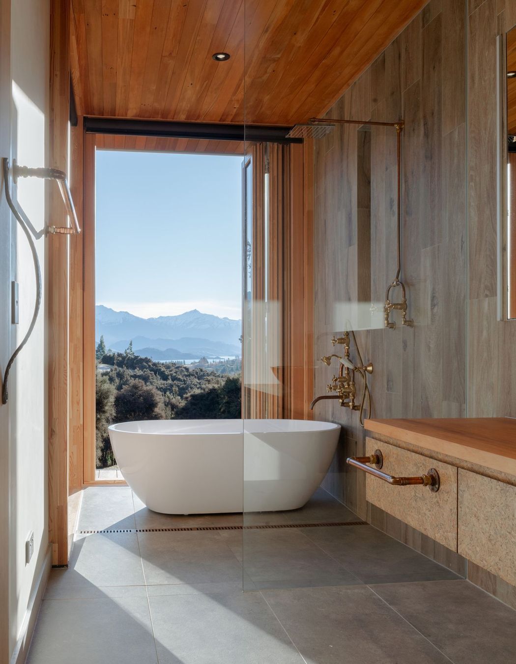 The wet-area shower features an industrial-style exposed copper pipe shower rail.