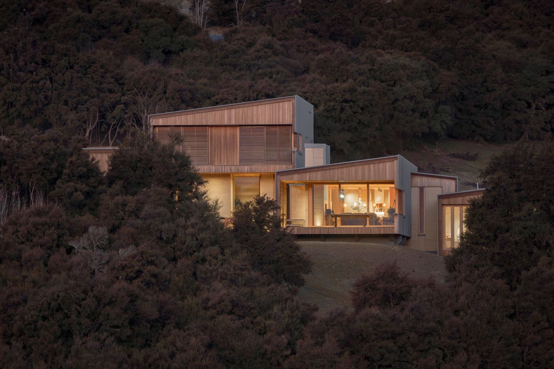 Dense kanuka bush borders the home and helps bed it into the landscape.