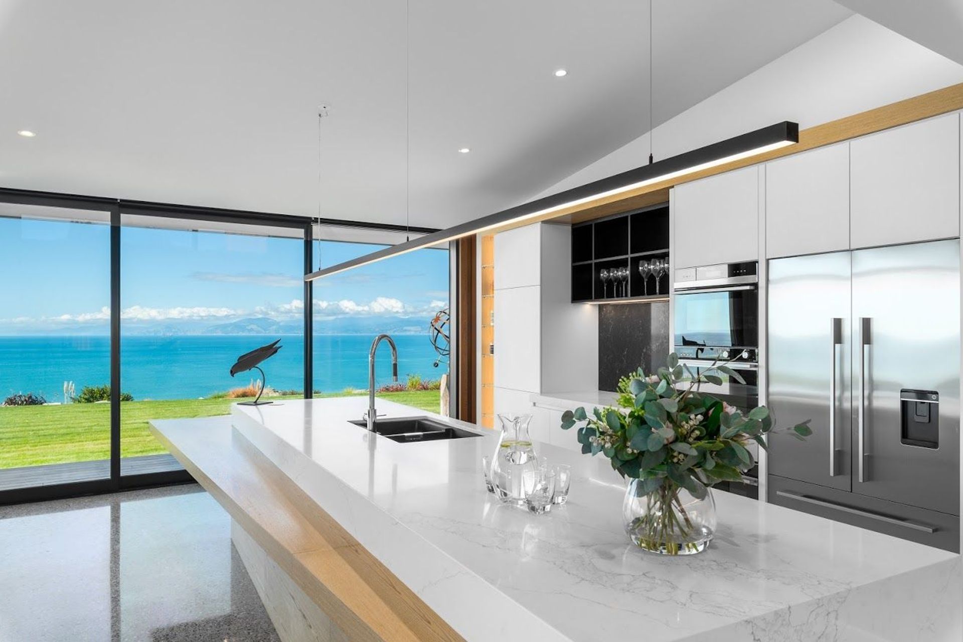 The interior uses light, natural hues and materials including concrete, timber and marble to give the space a breezy bach-like holiday feel.