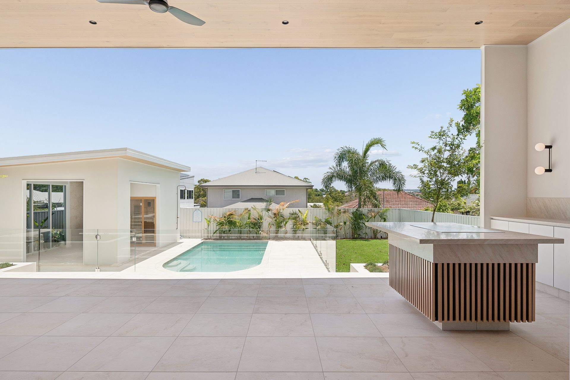 At dusk the pool becomes the garden's centrepiece, framed by mature palms.