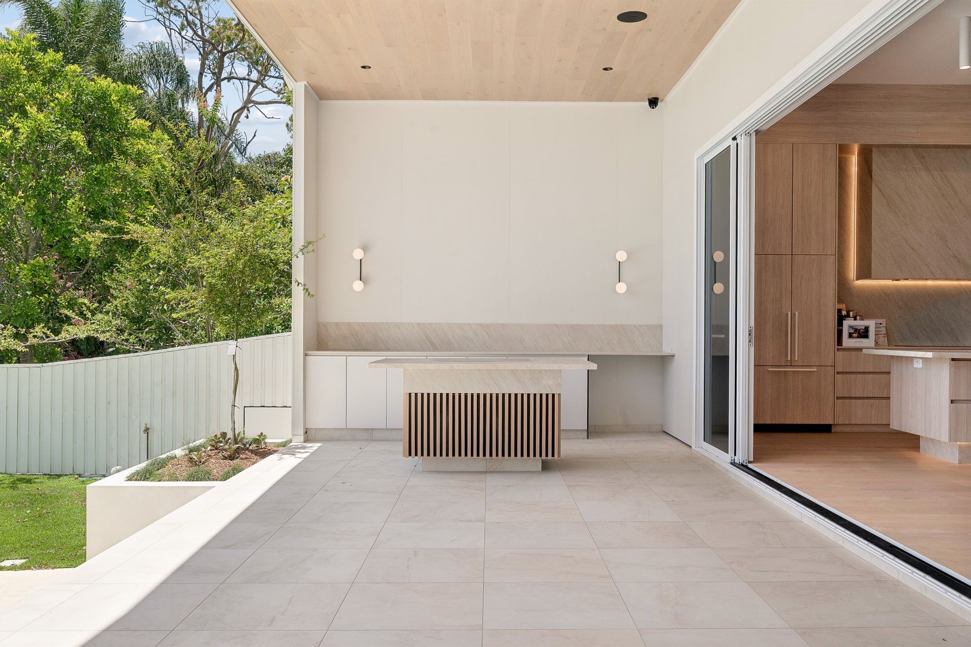 The outdoor pavilion sits right beside the pool, glass doors linking it back to the kitchen.