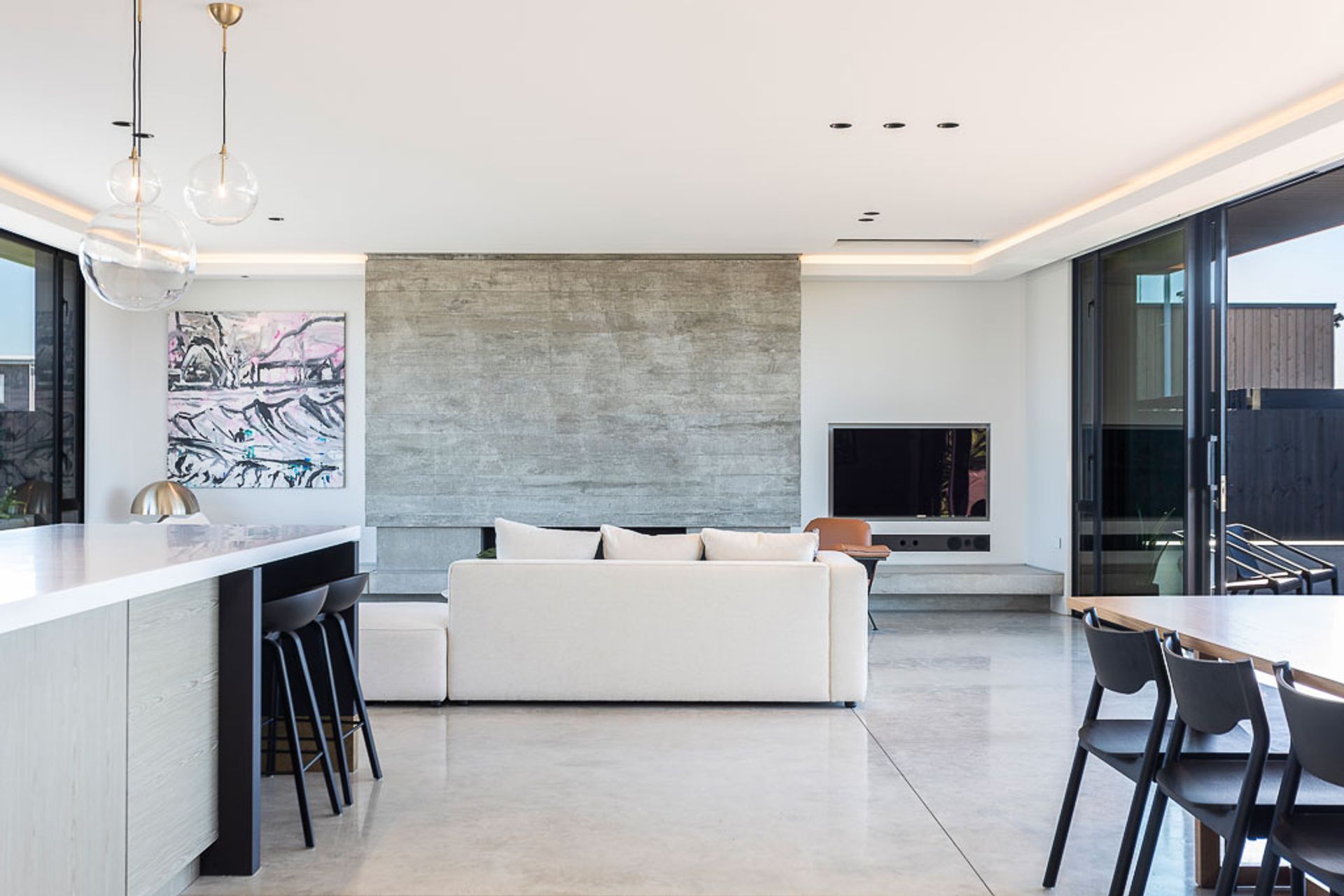 The main living space features extensive glazing and outdoor spaces on both sides.