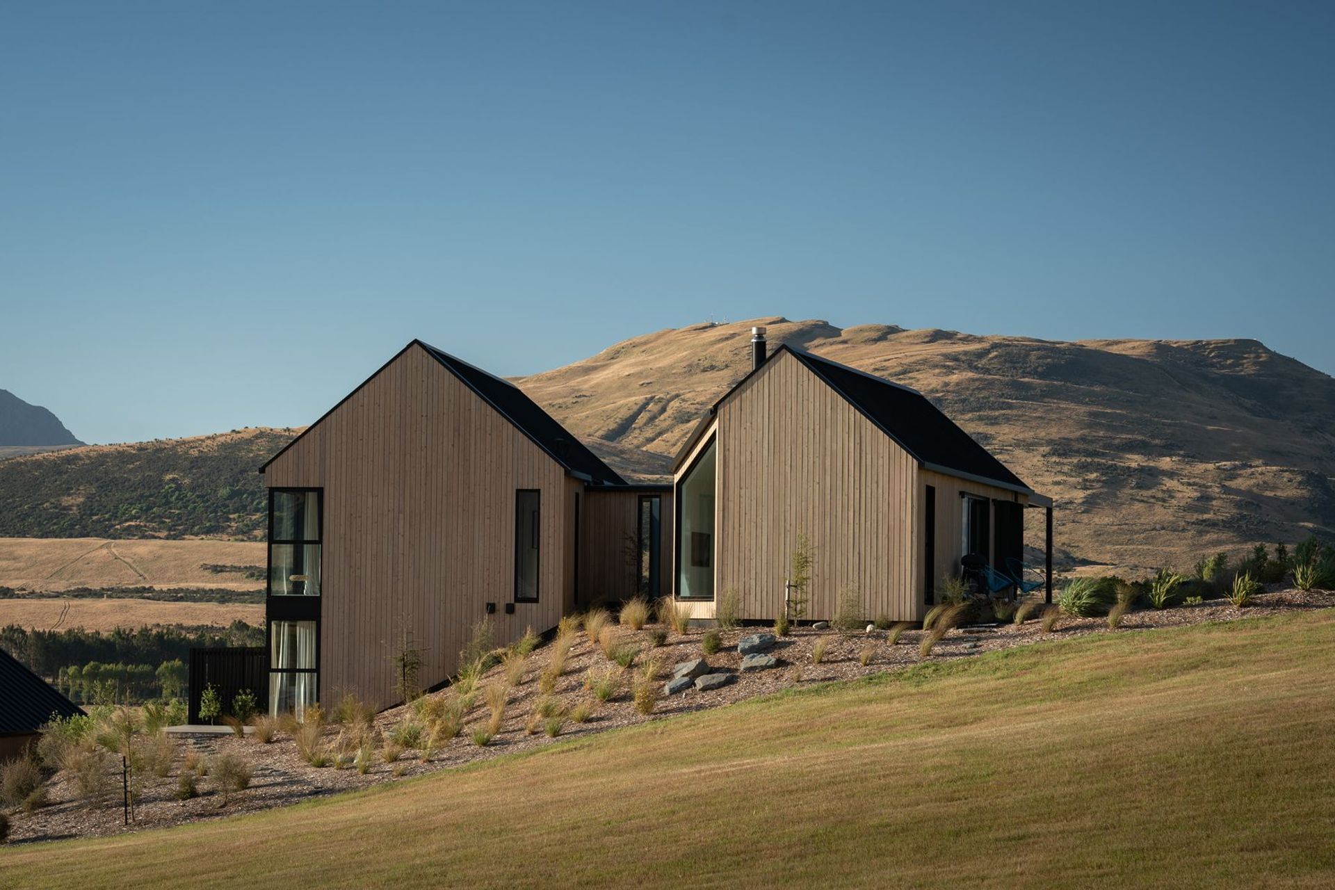 The home steps down the sloped site, which is adjacent to a public reserve.