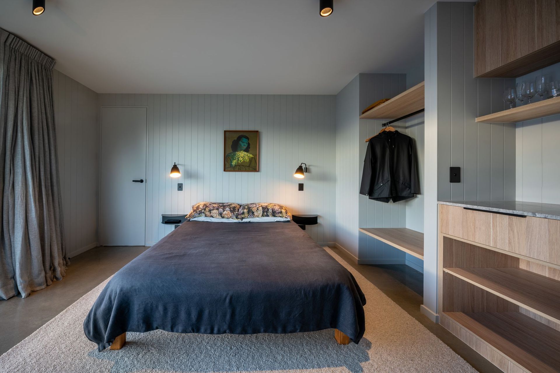Each bedroom uses a different soft hue on the grooved walls to express the space.