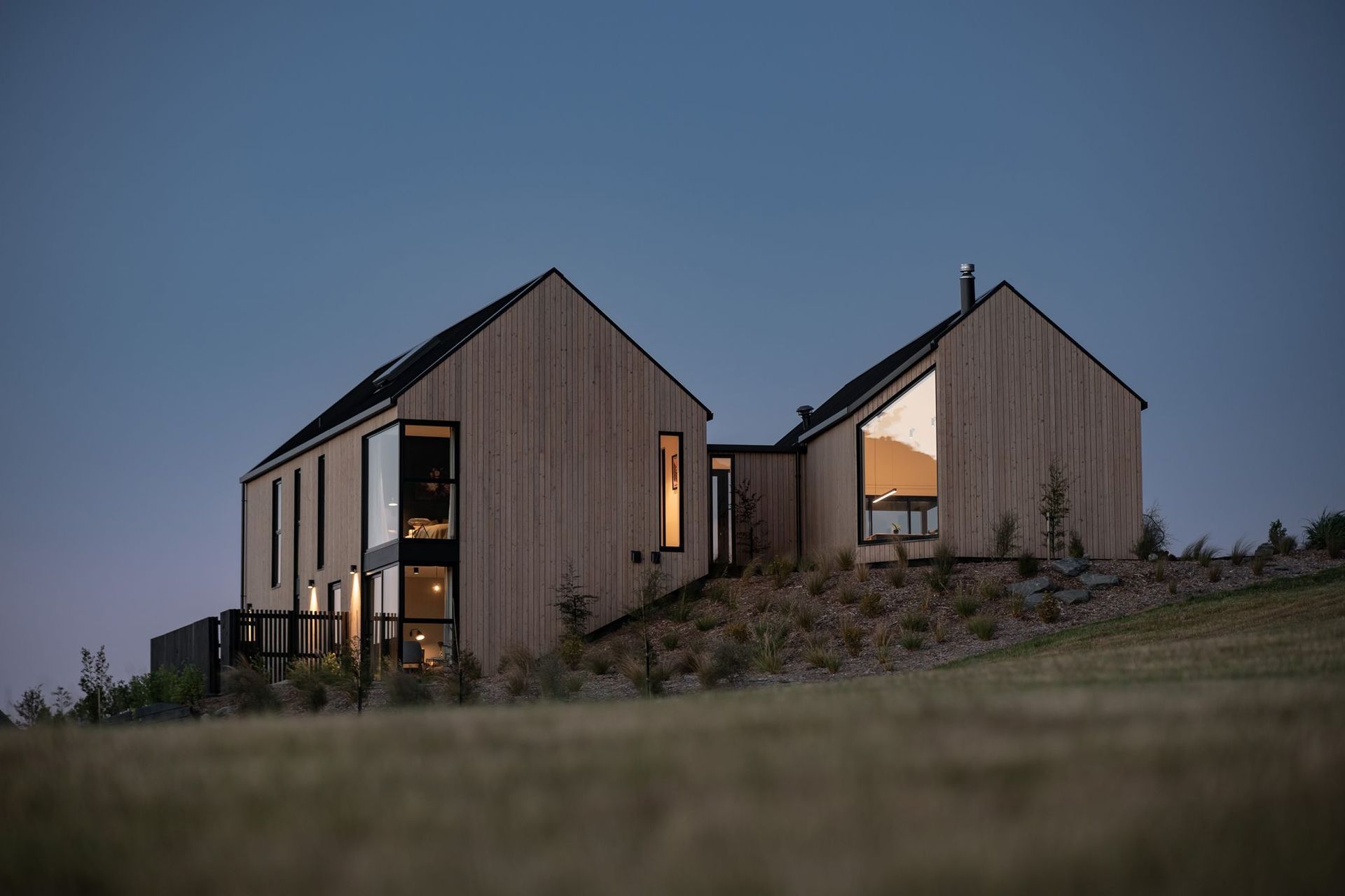 At dusk, the home takes on the same hues as the landscape.