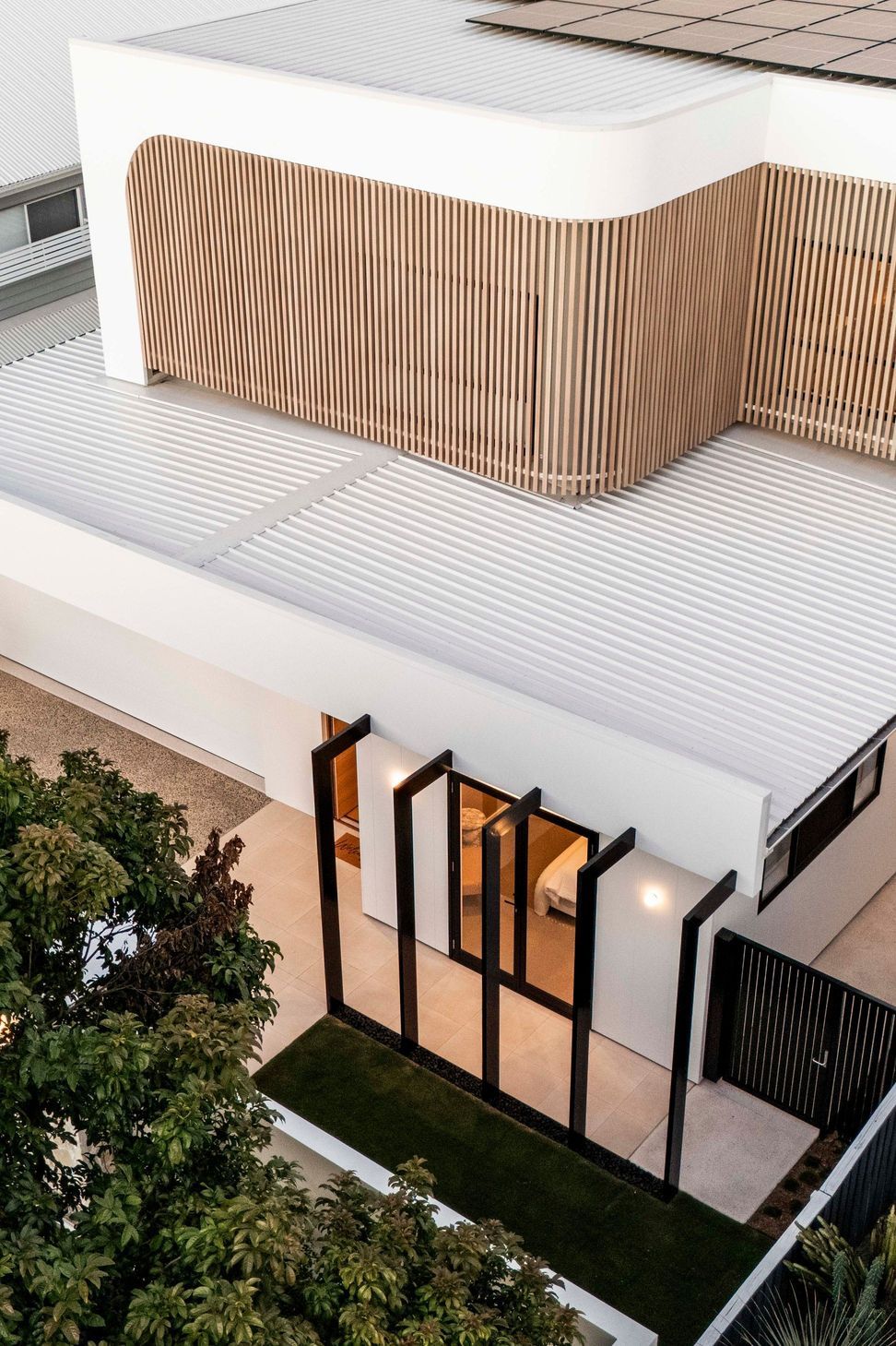From above, the curved screen wraps the upper level and rooftop solar sits out of sight.