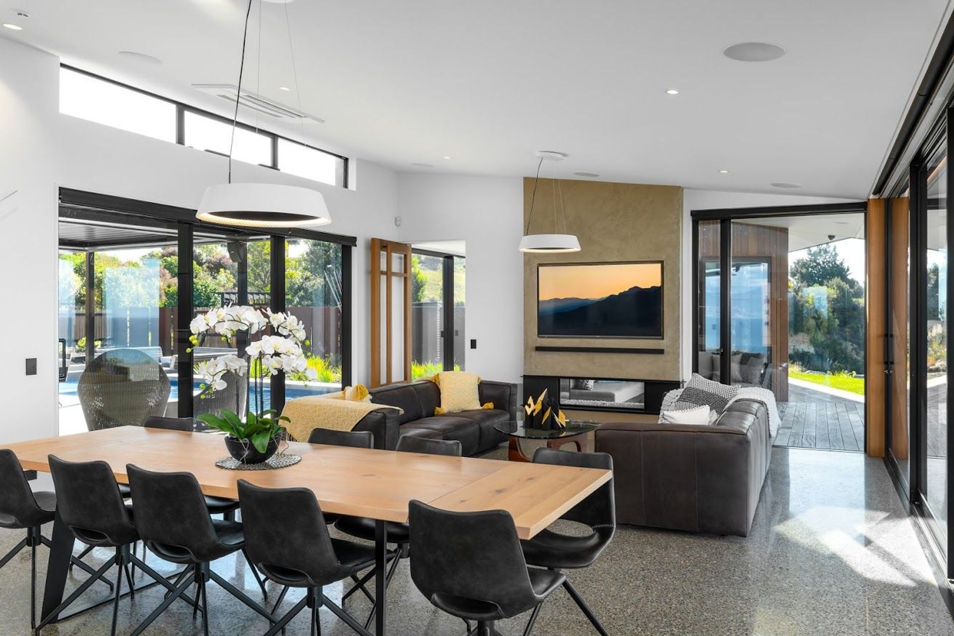 The central living, dining, lounge space looks through to the covered outdoor area through a two-way fireplace.