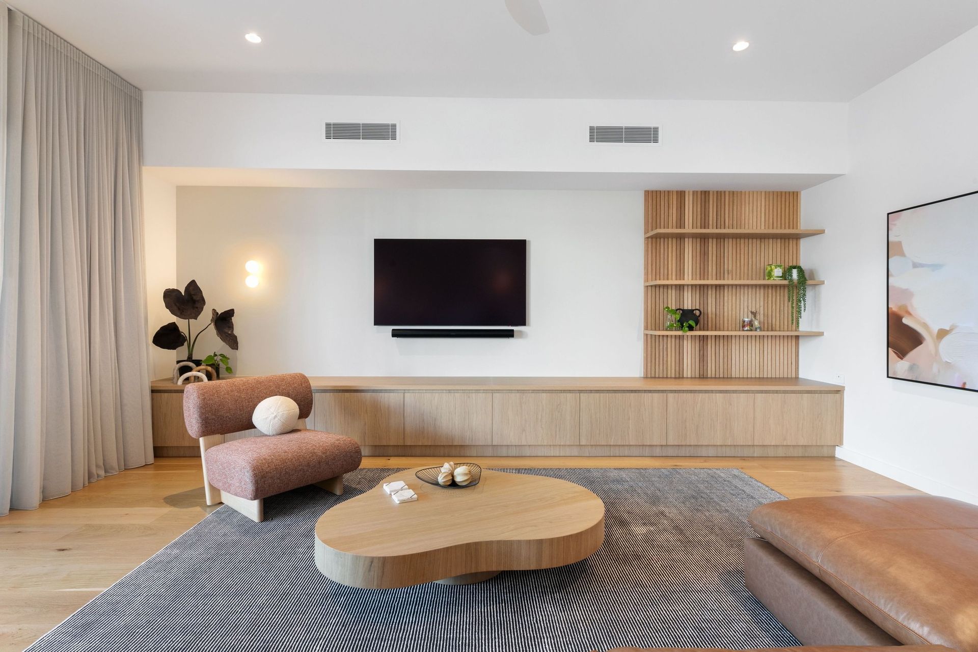 Fluted oak shelving anchors the living room without crowding it.