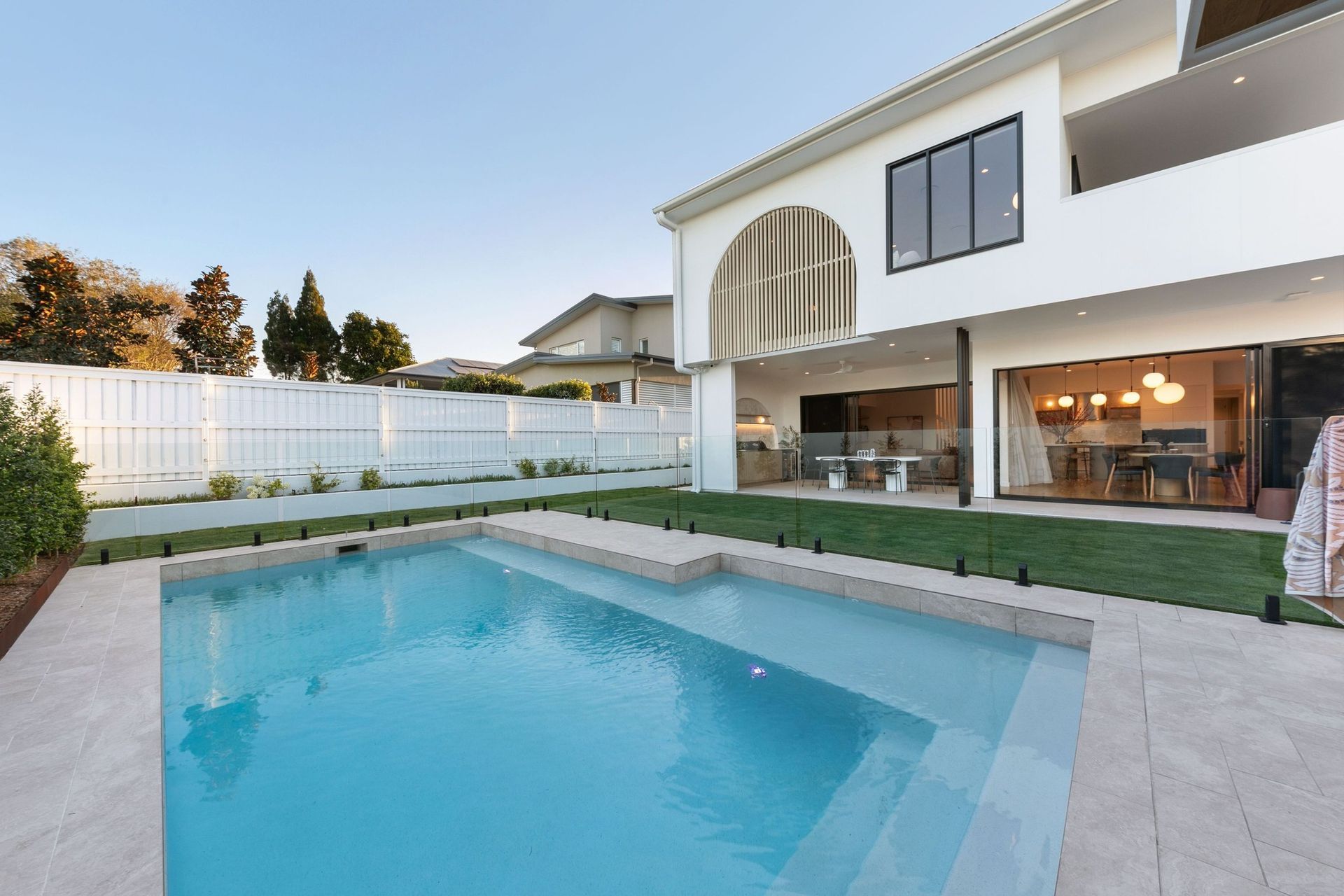 From the water, the arched batten screen reads as the home's signature gesture.