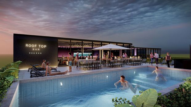 A dusk architectural rendering of a contemporary rooftop bar and entertainment venue beside a large swimming pool. The open-sided bar has extensive glazing, a flat roof, outdoor dining tables, lounge seating, and illuminated signage reading “ROOF TOP BAR.” People are shown using the pool and terrace, with planted landscaping around the pool perimeter.
