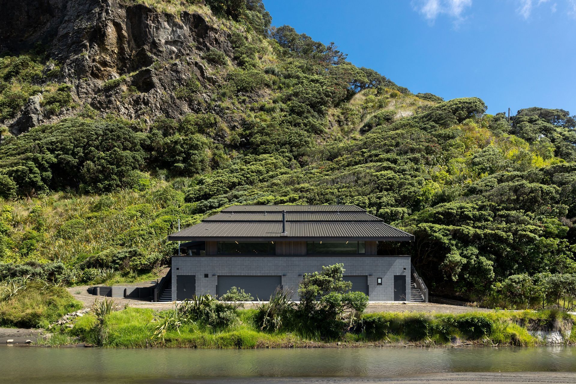 ©️ Jono Parker   The Karekare stream feeds out into the sea in front of the club, and it must be traversed to access the building.