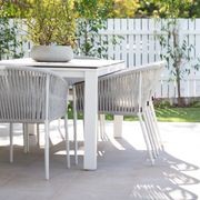 Lavarosa limestone alfresco outdoor terrace with white dining furniture and dappled sunlight