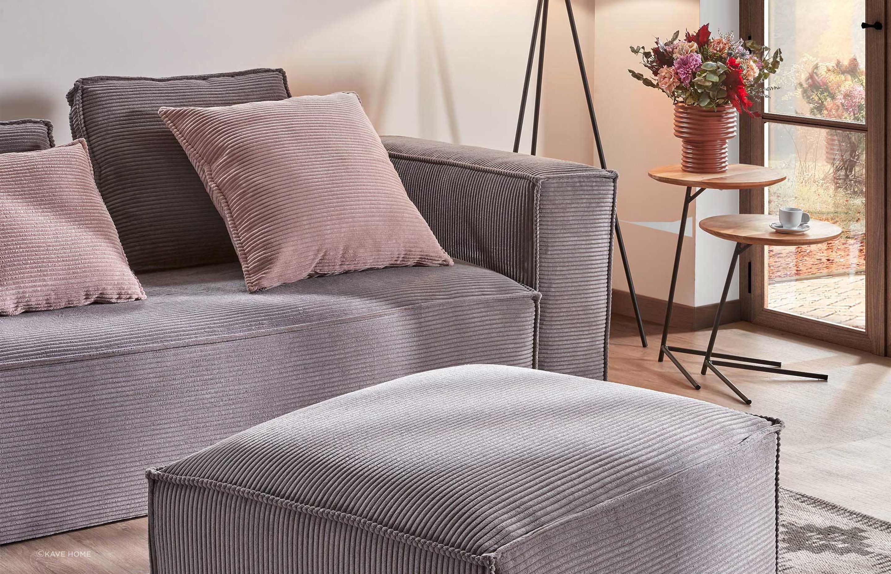Pretty in pink: Bright pink pillows add warmth to this Kave Home grey sofa.