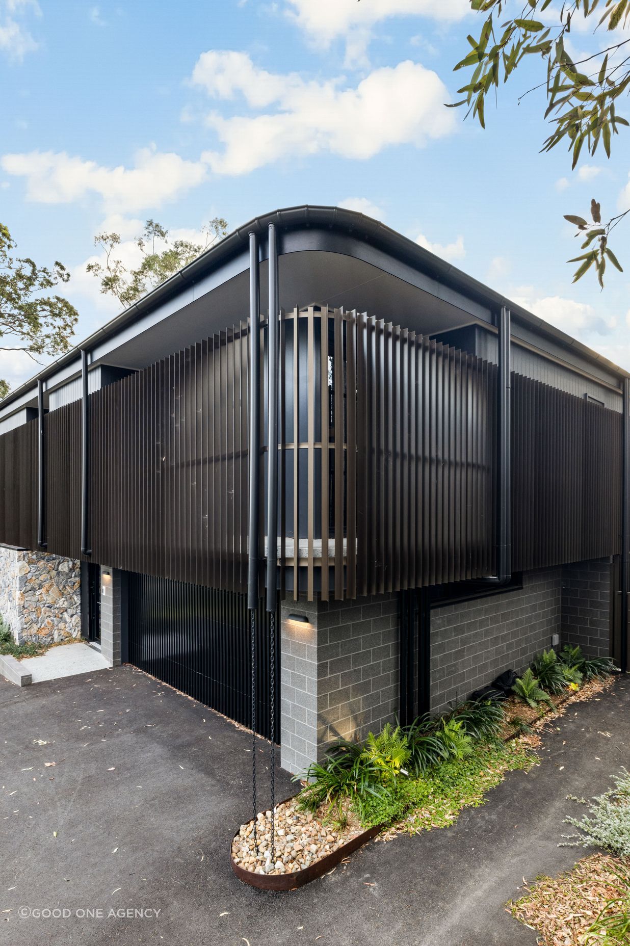 The form of the home avoids sharp lines, with the bronze coloured aluminium battens creating a soft, perforated.