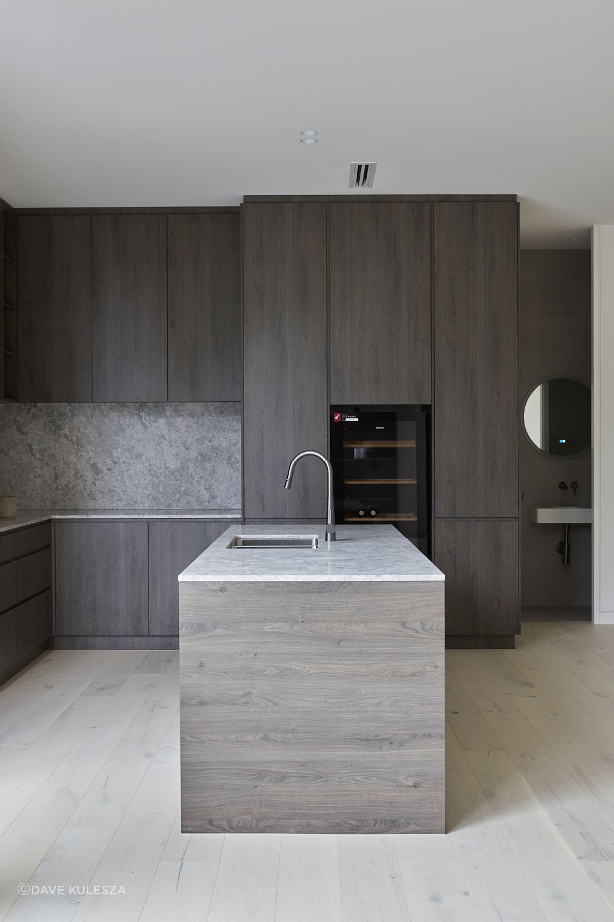 Floor to ceiling Nikpol designer cabinetry soften the built-in black appliances.