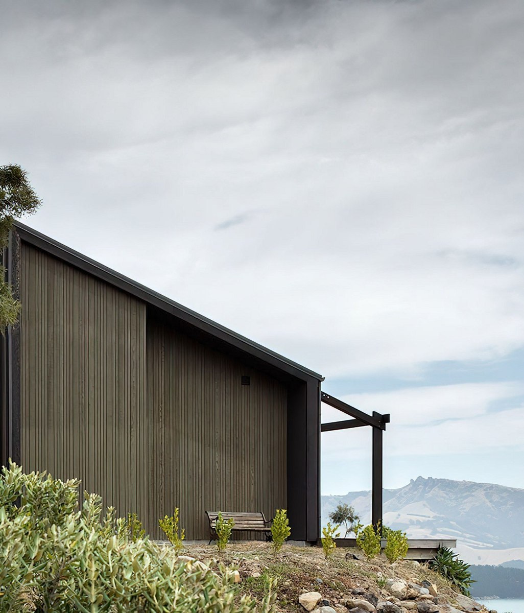 A cave-inspired home rising from a lava flow embankment
